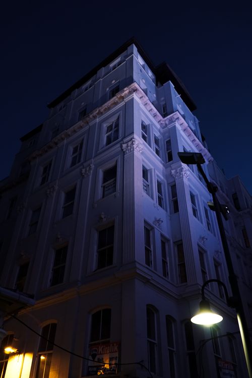 Free A striking low angle view of an illuminated building against the night sky, highlighting its architectural features. Stock Photo