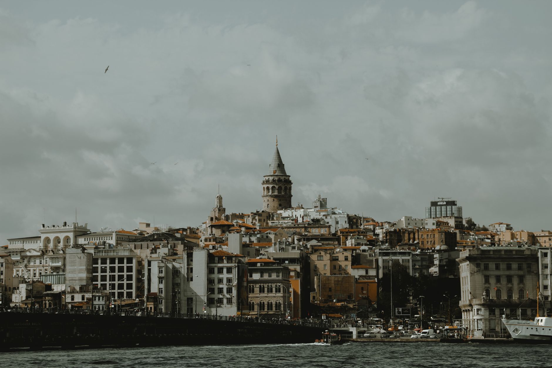 Dramatic cityscape of Istanbul with Galata Tower under a cloudy sky, showcasing urban architecture., Istanbul, Turkey, stay connected here with a travel eSIM