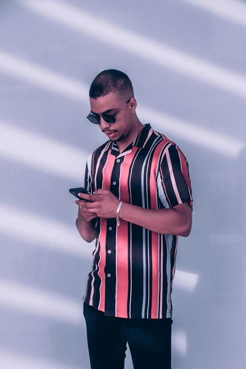 A Man in Stripe Polo Shirt a Holding Smartphone
