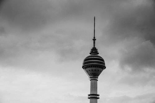 Free Dramatic black and white image of a tower against a cloudy sky, emphasizing its architectural design. Stock Photo