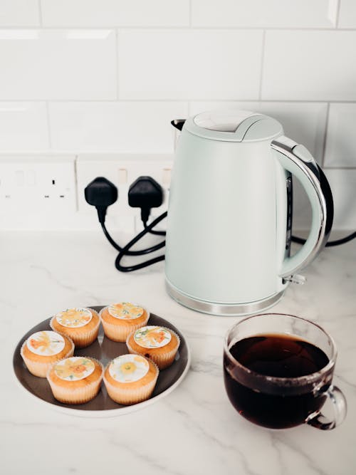 Cupcakes and Tea Cup next to Electric Kettle