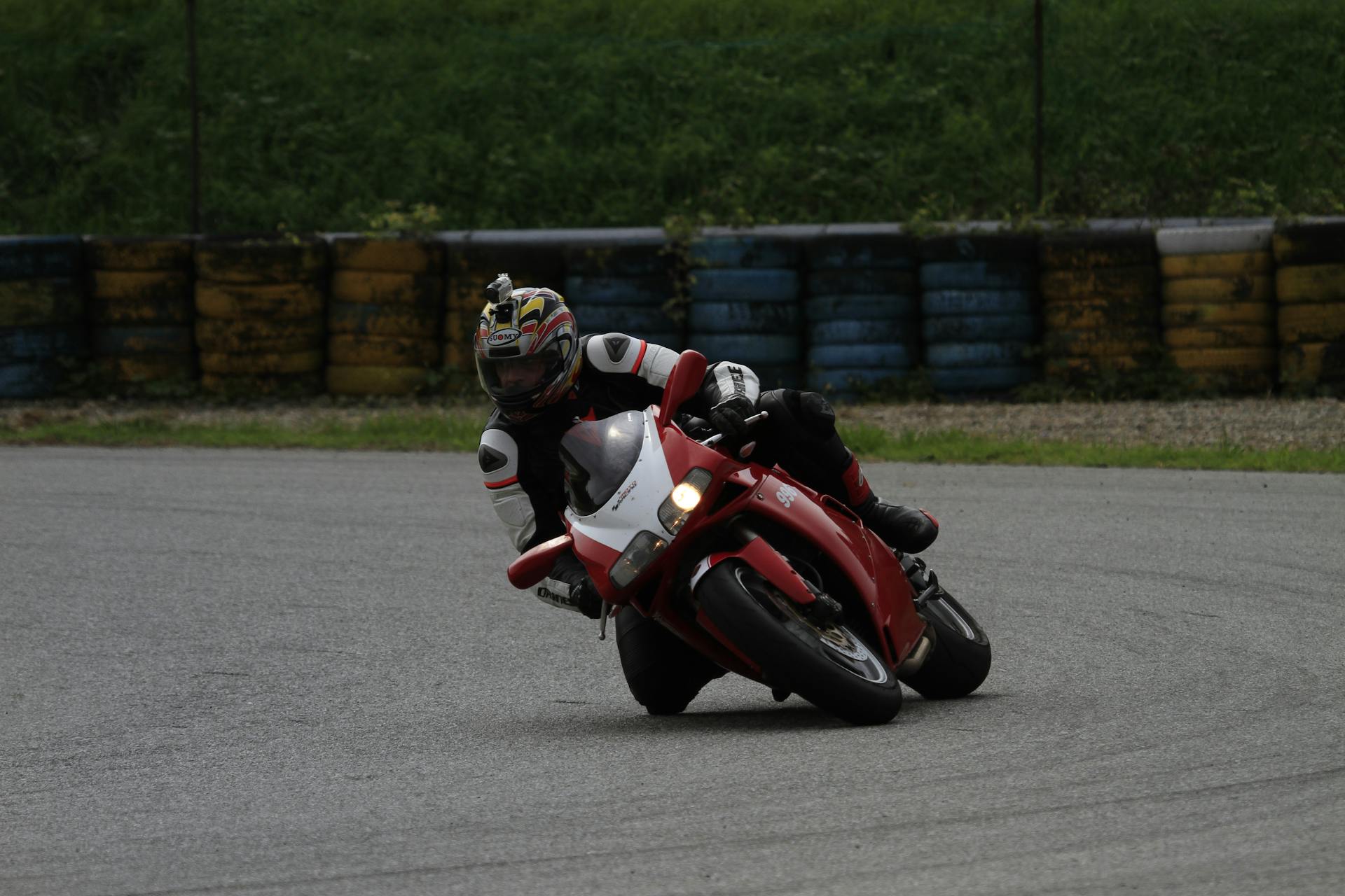 Motorcyclist leaning into a turn during a thrilling race on a vibrant track.