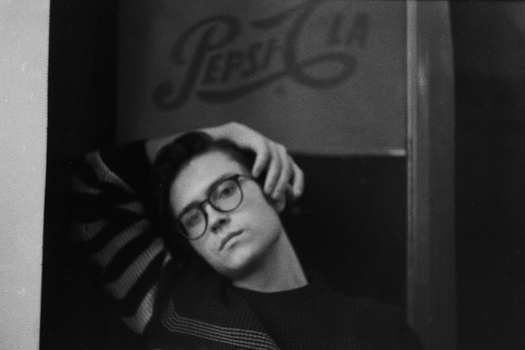 Artistic black and white portrait of a man posing with eyeglasses.