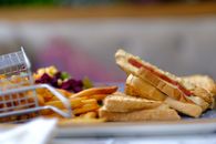 A delectable toasted sandwich paired with crispy golden French fries, perfect for a lunch snack.