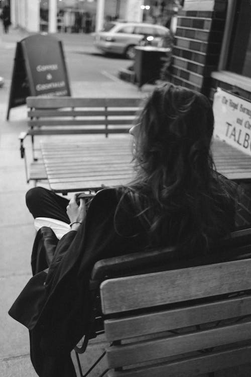Free Grayscale Photo of Woman Sitting on a Bench Stock Photo