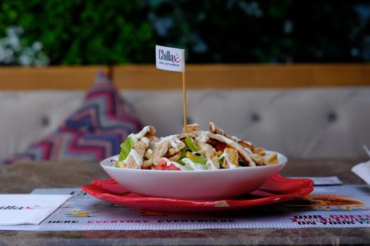 Close-up of a delicious chicken salad with fresh veggies in a stylish cafe, perfect for food lovers.