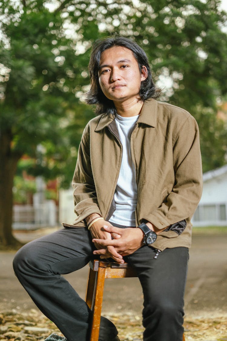 Man Sitting On Stool In Park