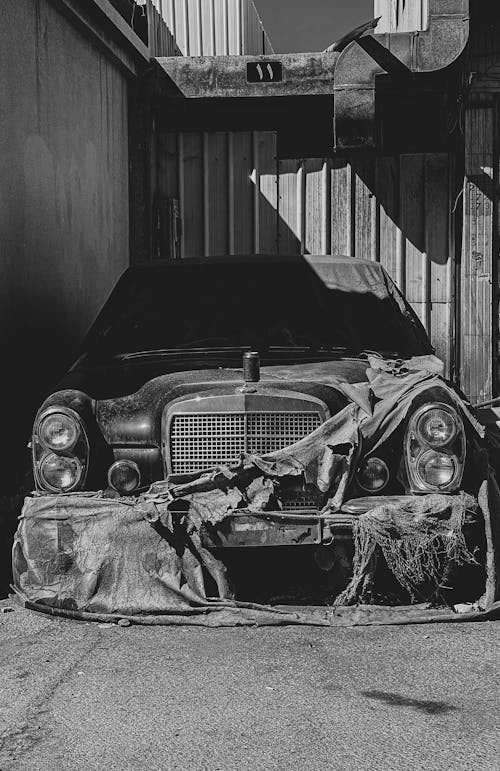 Grayscale Photo of a Dirty Vintage Car