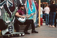 Man Playing Black Cutaway Guitar