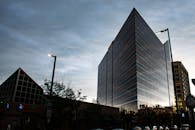 在繁华的城市中，一座时尚现代的摩天大楼映衬着黄昏的天空