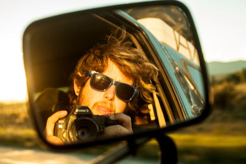 Photo of a Man with Sunglasses Holding a Camera