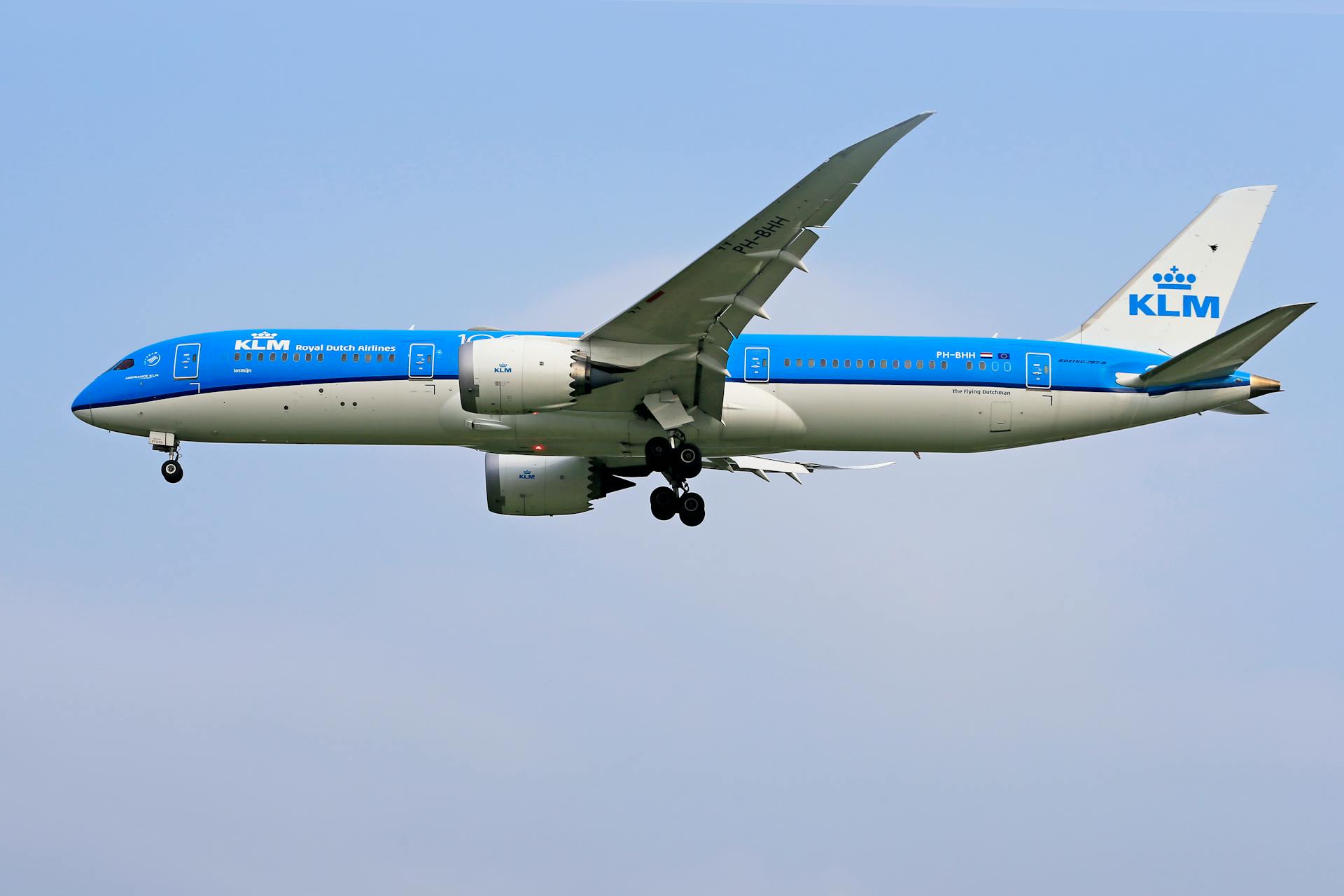 KLM Boeing 787 Dreamliner mid-air during the day against a clear sky.