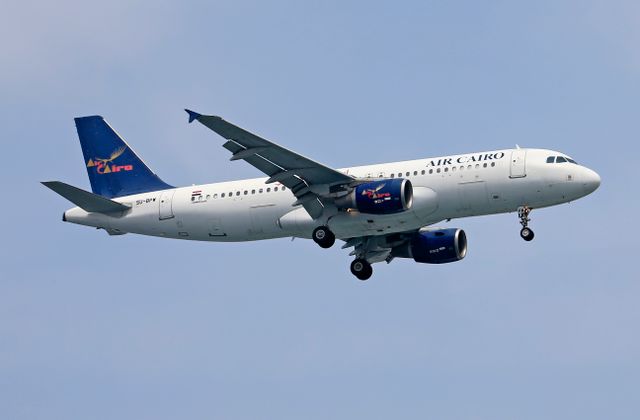 Air Cairo Airbus A320 flying against a blue sky, showcasing the airline's logo and design. — arriving in Cairo
