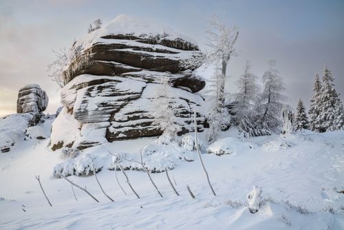 Free Stunning snow-covered rock formations and trees in a serene winter landscape. Stock Photo