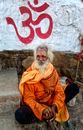 An Elderly Man in Orange Long Sleeves Sitting on the Street