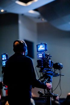 Expert cameraman recording with high-tech video camera in a studio setting.