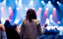 Woman in Brown Jacket Standing and Looking at the Lights