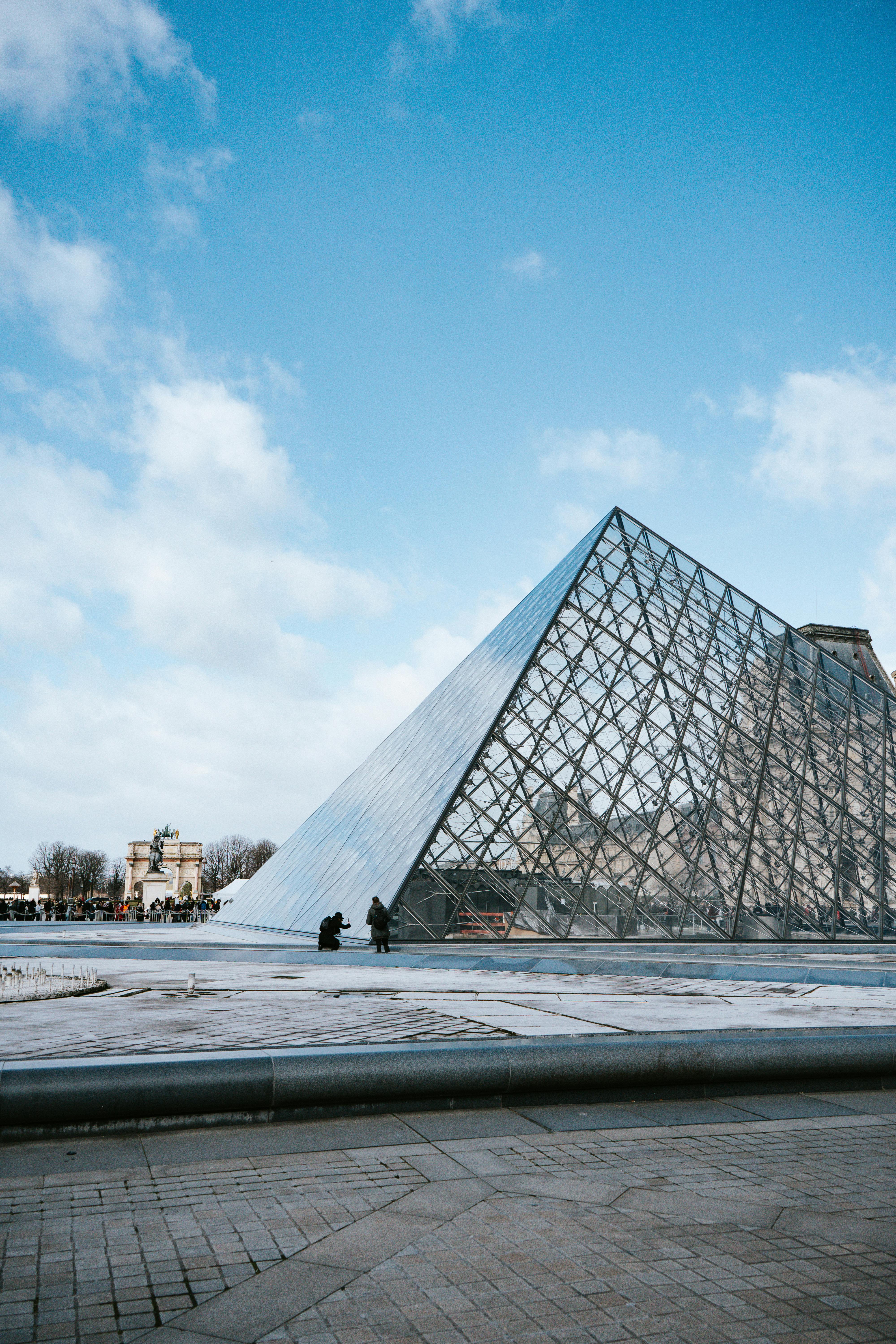 a louvre museum under the white clouds and blue sky