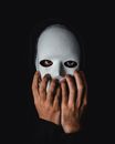 Person Covering Face With White Mask
