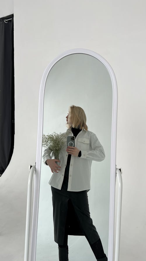 Free Woman in Gray Blazer Standing in Front of Mirror Stock Photo