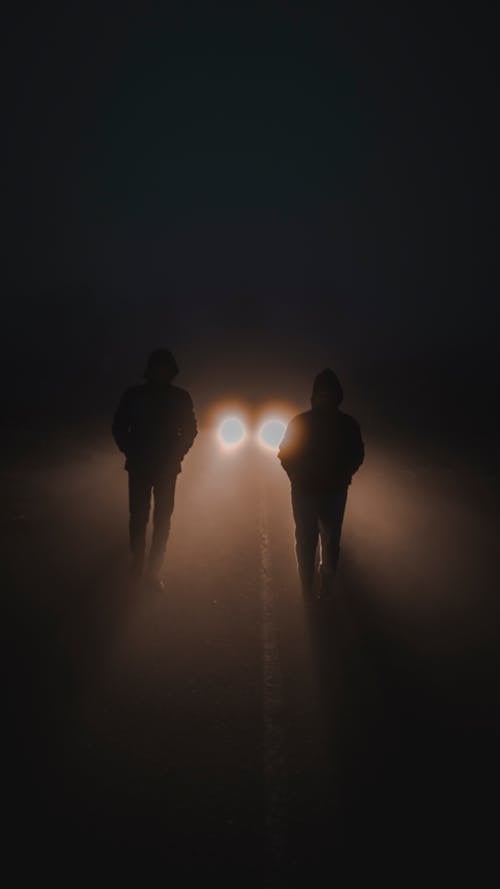 A Car Behind People Walking on the Road