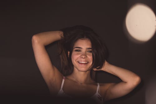 Smiling Woman in Lingerie on Dark Background