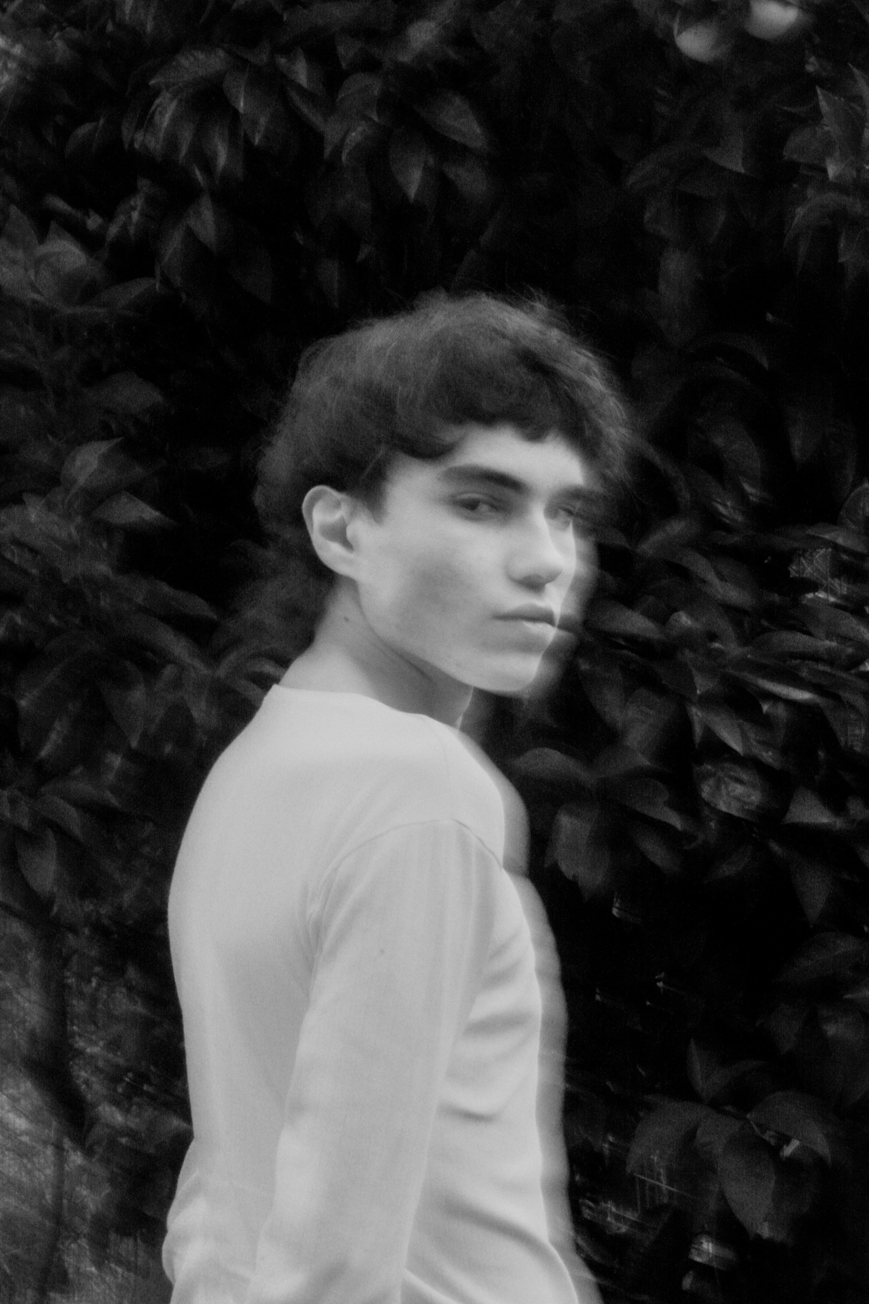 Blurred black and white portrait of a man in motion with a mysterious gaze.