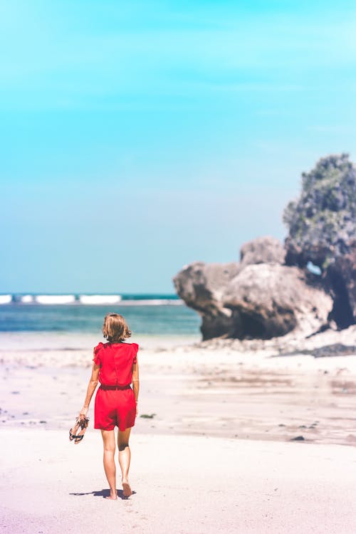 Woman Holding Sandals in the Shore