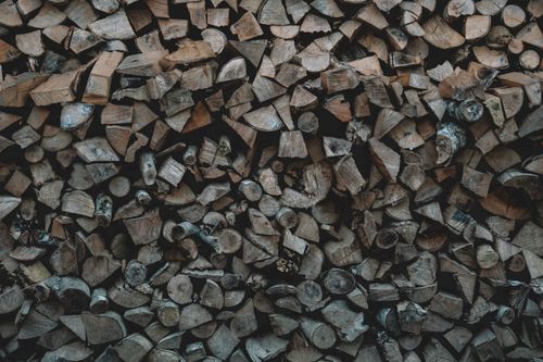 Free A detailed view of a large pile of chopped wood, showing the natural texture for fuel or fireplace use. Stock Photo