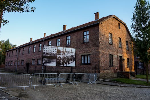 Brick building at Auschwitz with historical photos displayed, Poland.