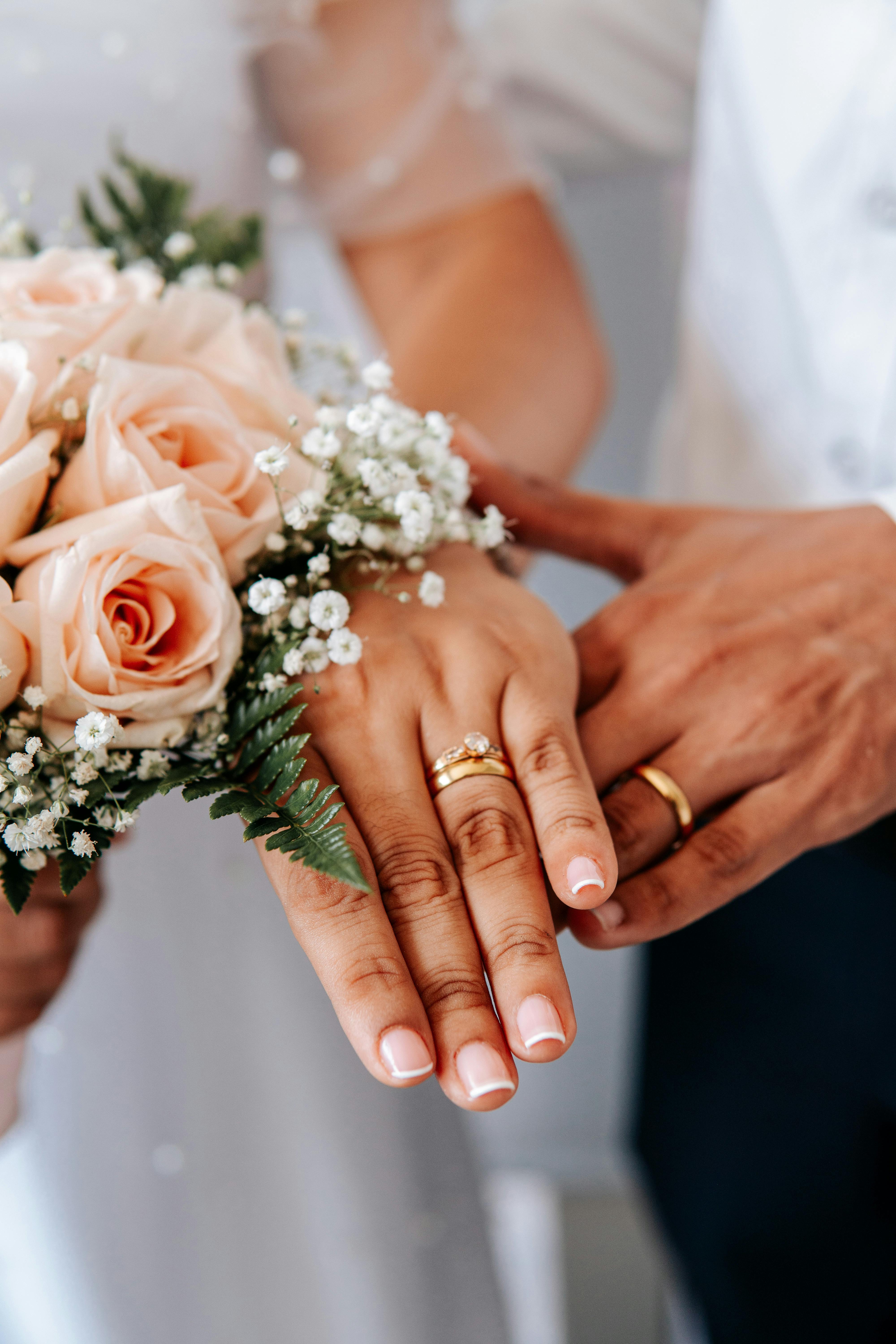 hands of husband and wife with wedding rings. Stock Photo | Adobe Stock