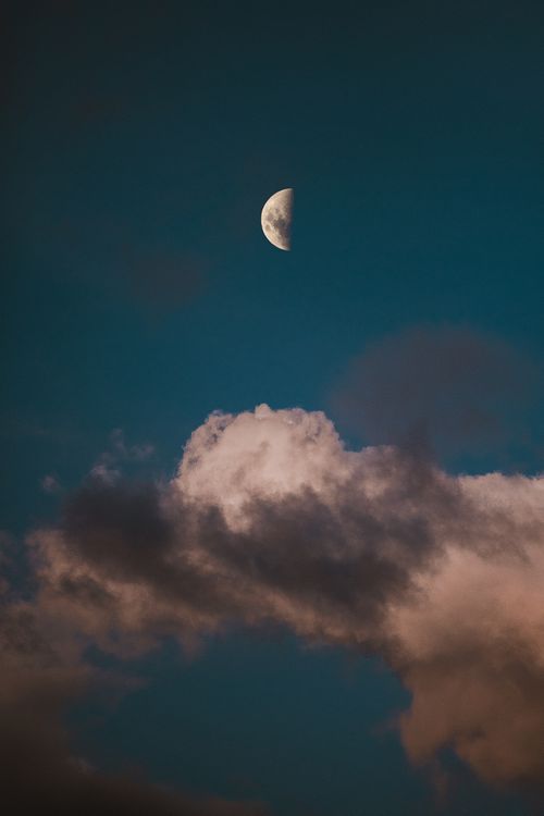 Free Half moon in a dramatic night sky over Brasília, featuring dark clouds and twilight hues. Stock Photo
