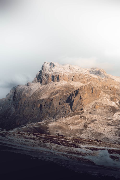 Free A Rocky Mountain under a Cloudy Sky Stock Photo