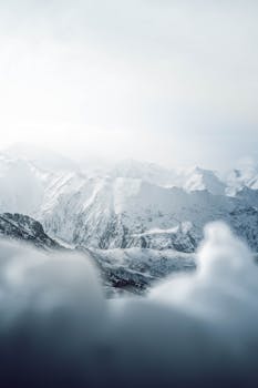Breathtaking view of a snowy mountain range under a soft winter sky.