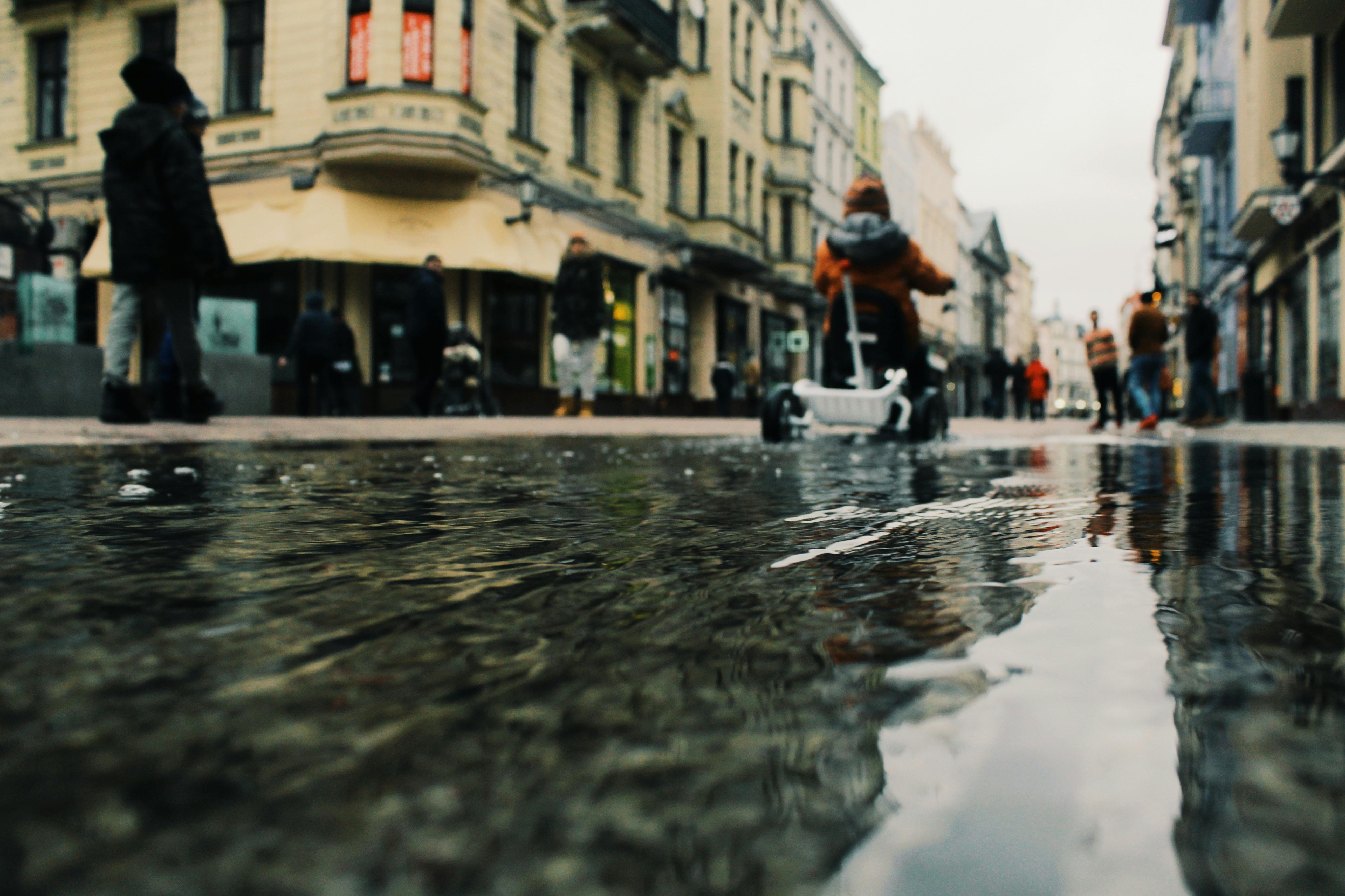 雨天，波兰托鲁什的城市街道以倒影和行人为特色，氛围独特