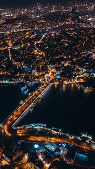 A breathtaking aerial view of Istanbul at night, showcasing illuminated streets and the Bosphorus Strait.
