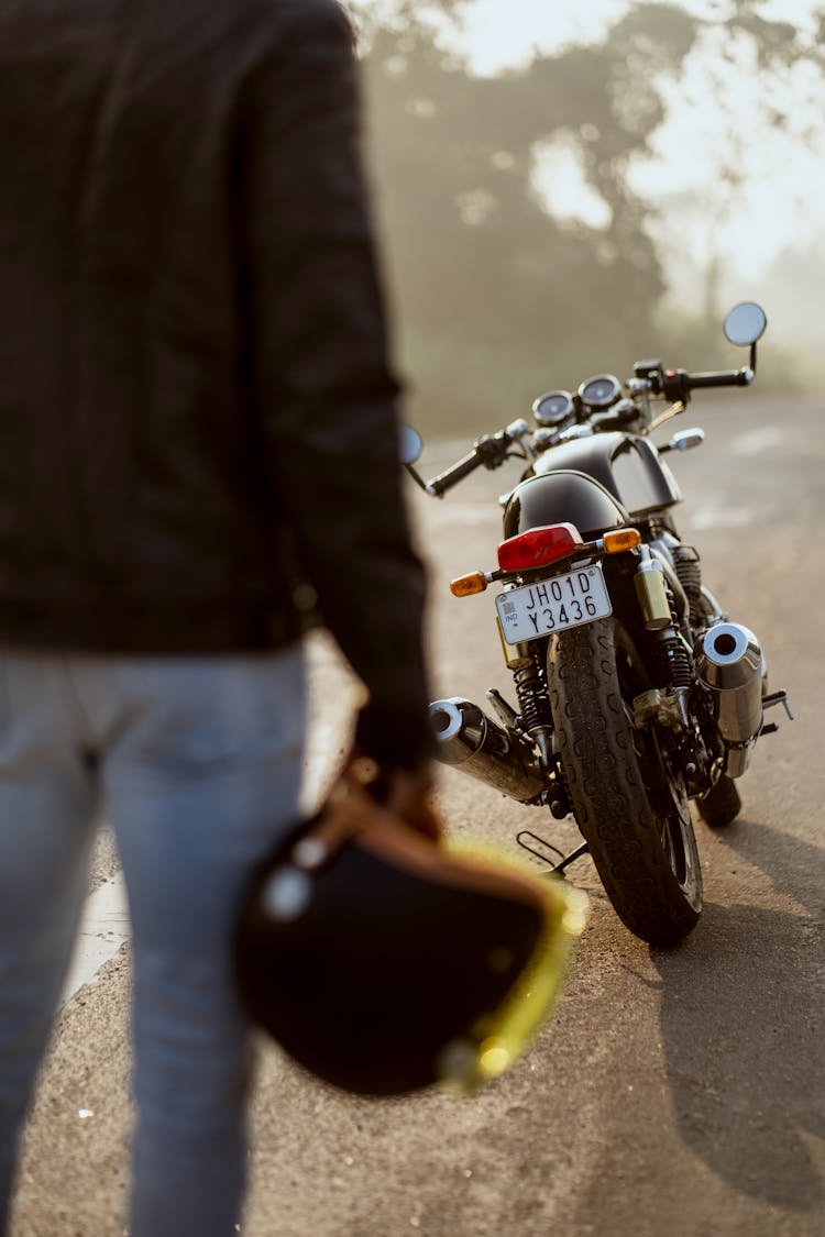 Back View Of Man With Helmet And Motorcycle