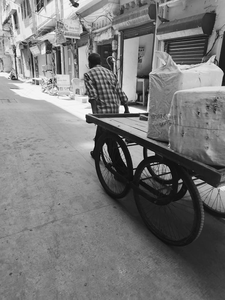 Man Carrying Bags On Cart