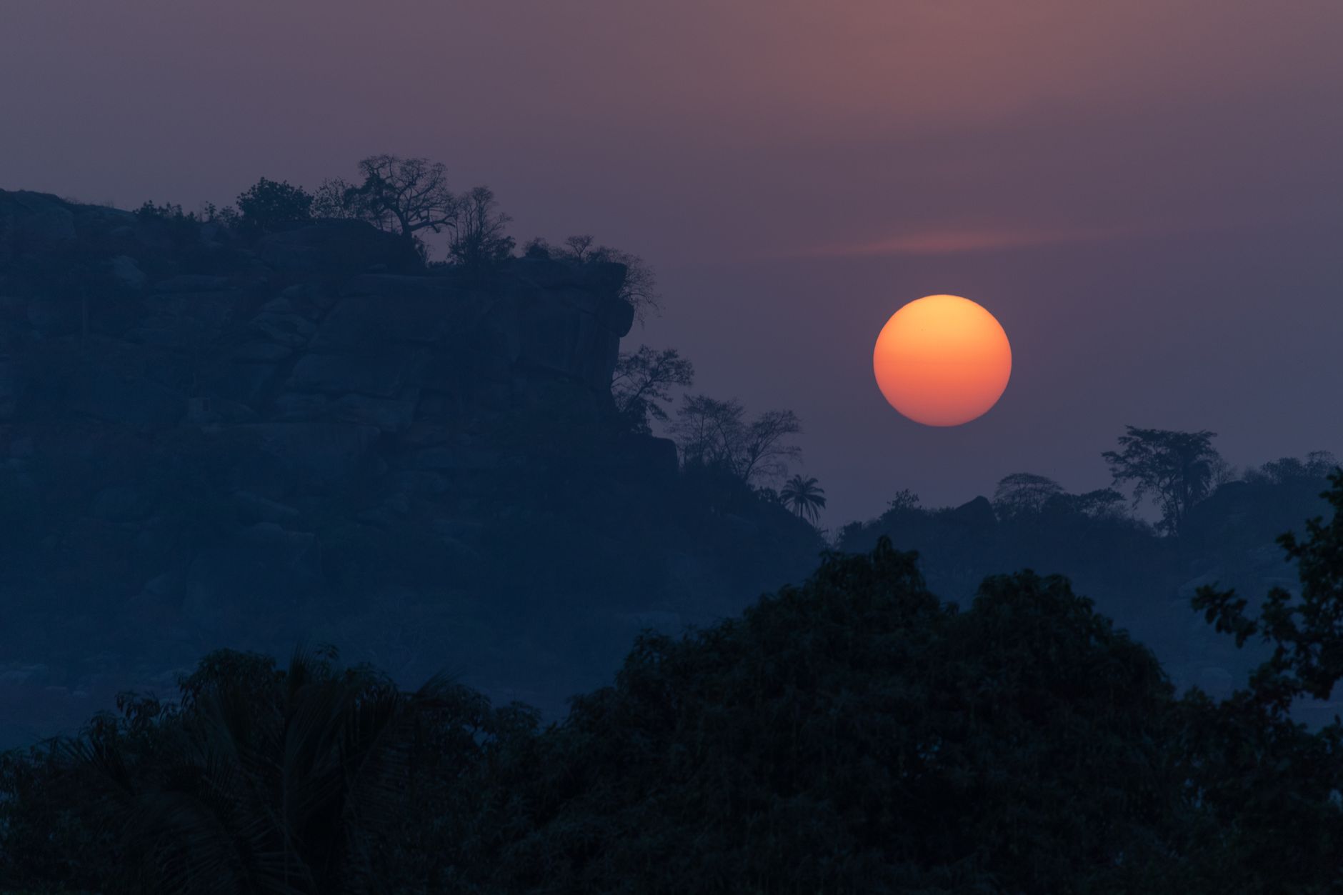 Breathtaking sunset over Dassa-Zoumé, Benin, showcasing a vibrant sky and silhouetted landscape.