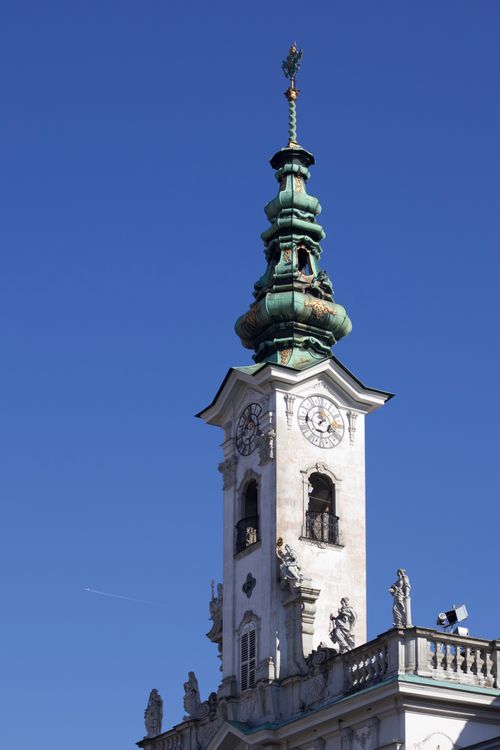 Free Low-angle view of a baroque church tower with intricate details against a clear blue sky. Stock Photo