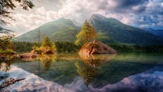 白天，德国的高山湖泊景观与山脉倒影交相辉映