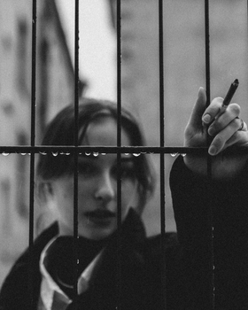 A Woman Smoking a Cigarette and Looking at Camera