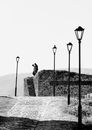 Grayscale Photo of Man Sitting on Concrete Bench