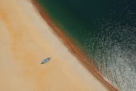 一艘孤独的船停在金色的沙滩上，晴朗的天空下波涛汹涌