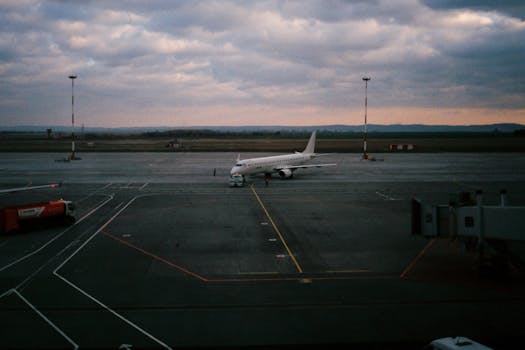 A commercial airplane on a tarmac at dusk, showcasing aviation and travel setting.