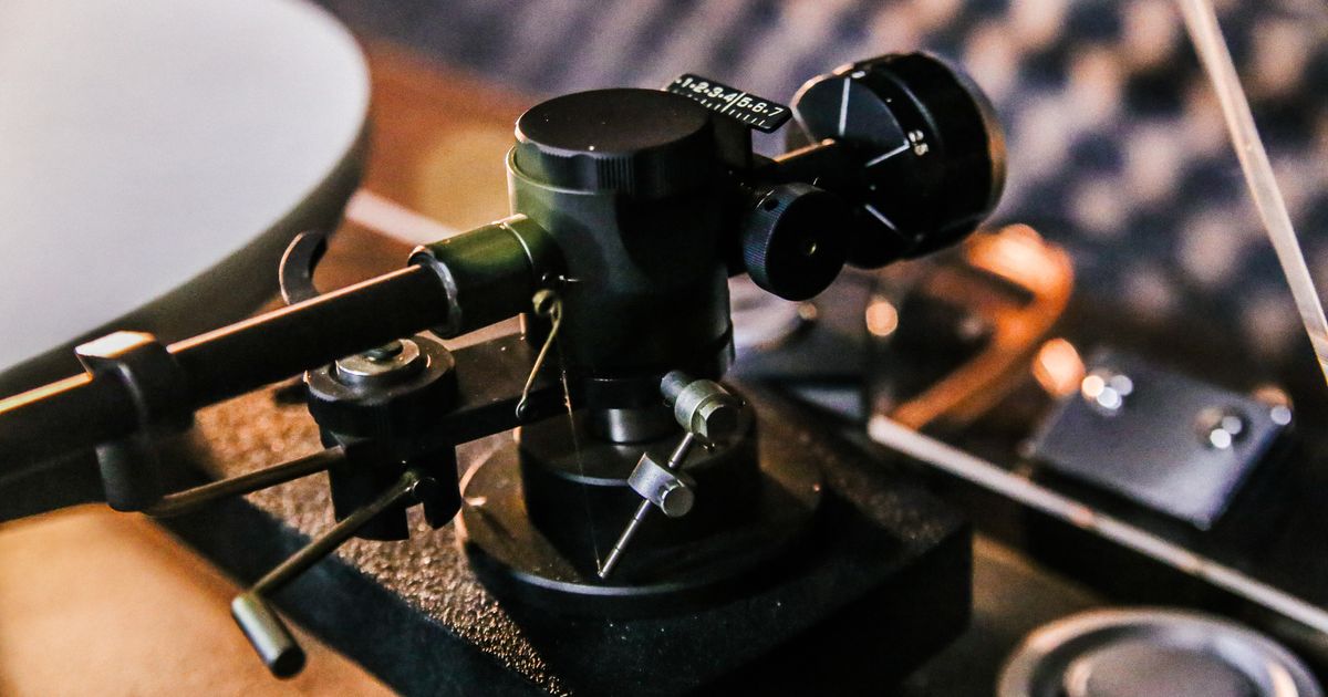 Detailed close-up of a vintage turntable tonearm, emphasizing retro audio equipment.