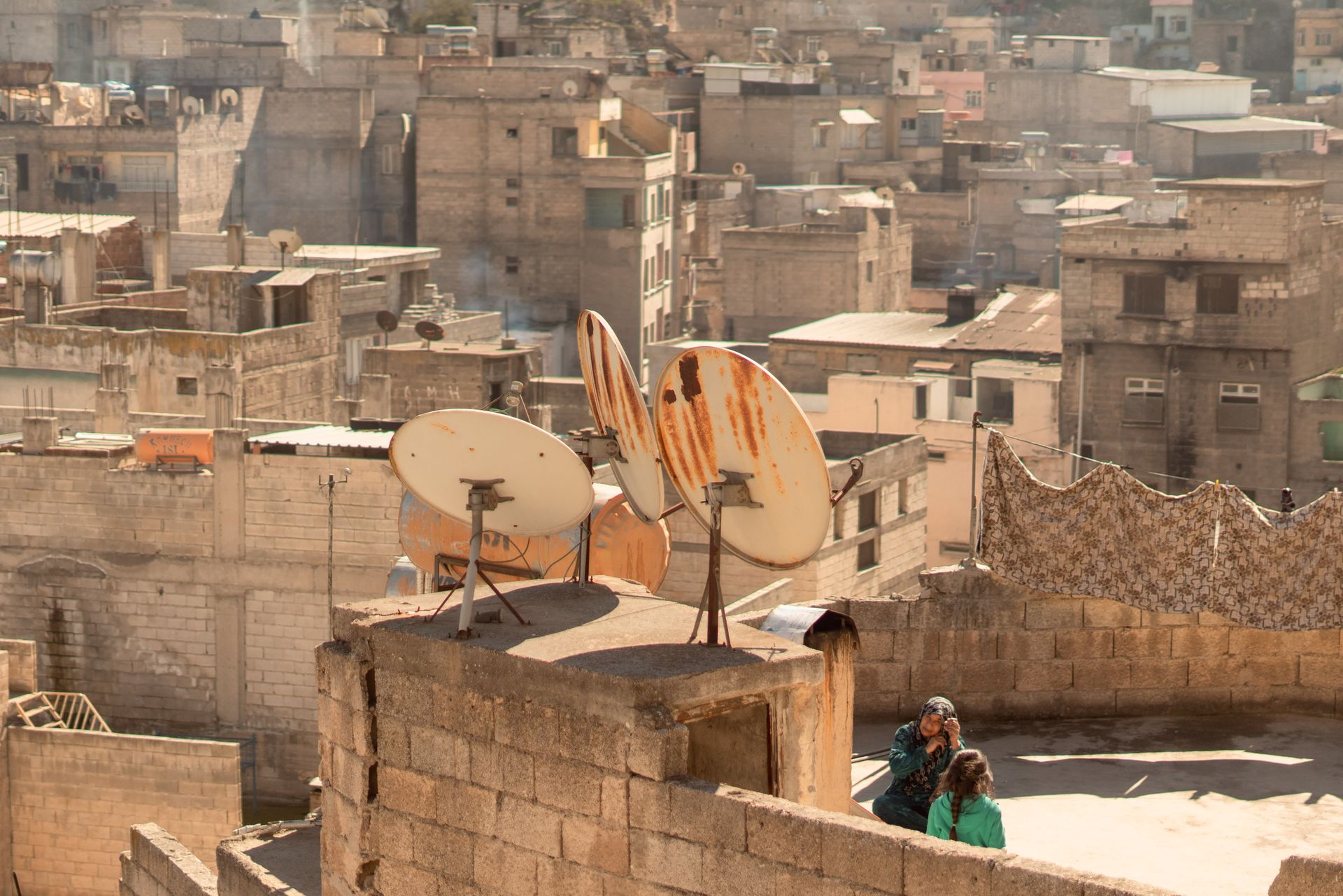 Rustic rooftops and satellite dishes in Birecik, Şanlıurfa, capturing urban life's texture.