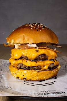 Mouth-watering triple cheeseburger with melted cheese and sesame bun.