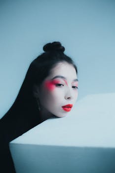 Creative studio portrait of a woman with red makeup and minimalistic composition.