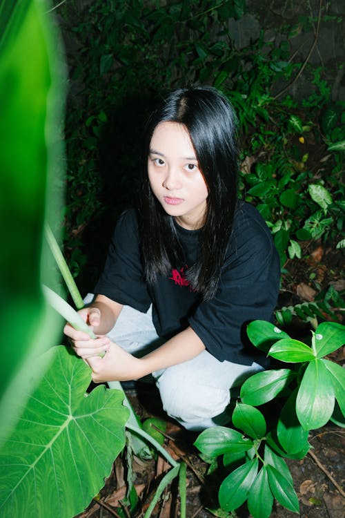 Woman in Black Shirt Sitting near Plants